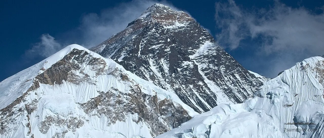 Snow-covered peak of Mount Everest against a blue sky